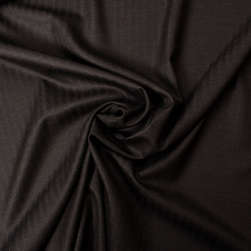 Close-up of black herringbone fabric for a men's tailored suit