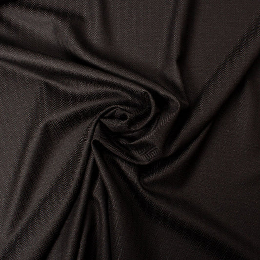 Close-up of black herringbone fabric for a men's tailored suit